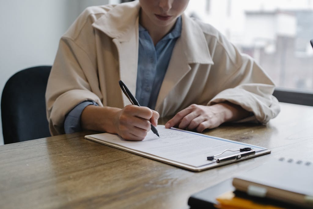 Focused woman writing in clipboard while hiring candidate